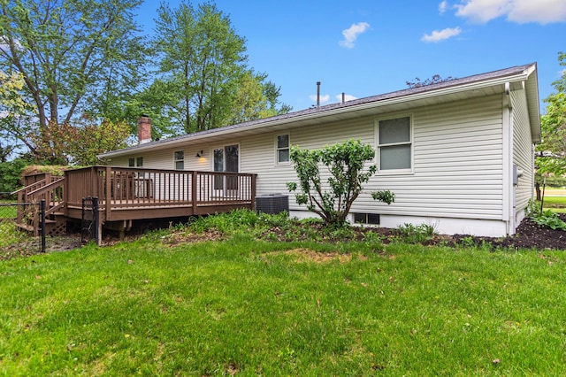 rear view of house with a chimney, central AC unit, a yard, and a deck