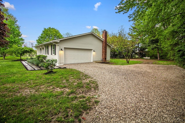 view of side of home with a lawn, a chimney, and gravel driveway