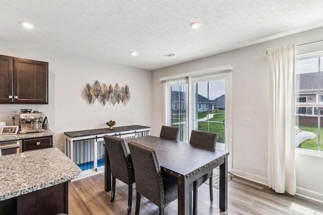 dining area with recessed lighting, baseboards, light wood finished floors, and a textured ceiling