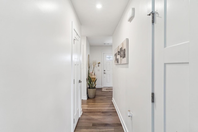 hallway with baseboards and wood finished floors