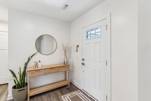 entryway featuring baseboards, dark wood finished floors, and visible vents