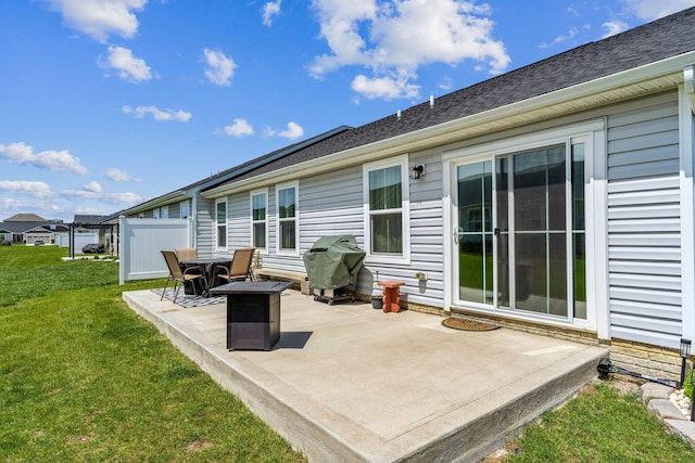 rear view of property with a lawn and a patio