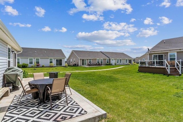 view of yard featuring a residential view, a patio area, a deck, and outdoor dining space