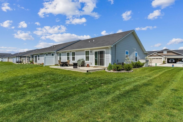 back of property featuring a lawn, a patio, and a shingled roof