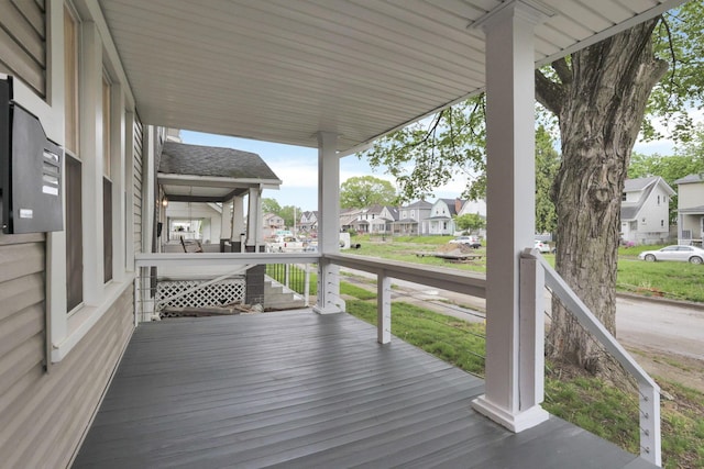 wooden terrace with covered porch and a residential view
