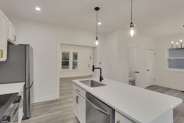 kitchen with a sink, light wood-style flooring, appliances with stainless steel finishes, and white cabinetry