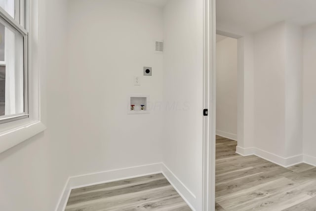 washroom with baseboards, hookup for an electric dryer, light wood finished floors, and hookup for a washing machine