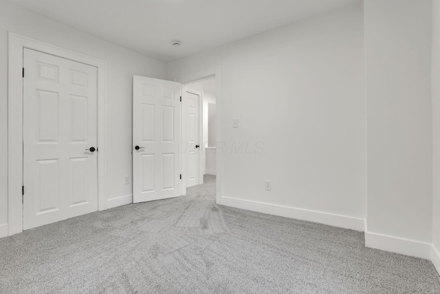 unfurnished bedroom featuring baseboards and carpet