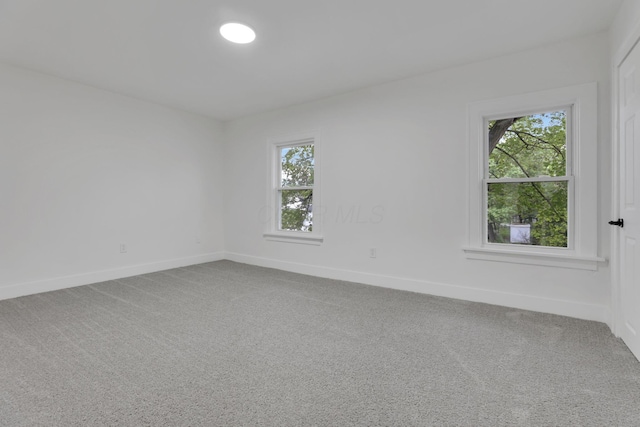 spare room featuring baseboards and carpet floors