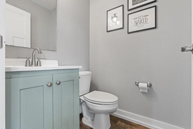 10695 State Route 93 N, Logan, OH 43138 - bathroom featuring baseboards, vanity, toilet, and wood finished floors