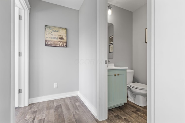10695 State Route 93 N, Logan, OH 43138 - bathroom featuring vanity, baseboards, toilet, and wood finished floors