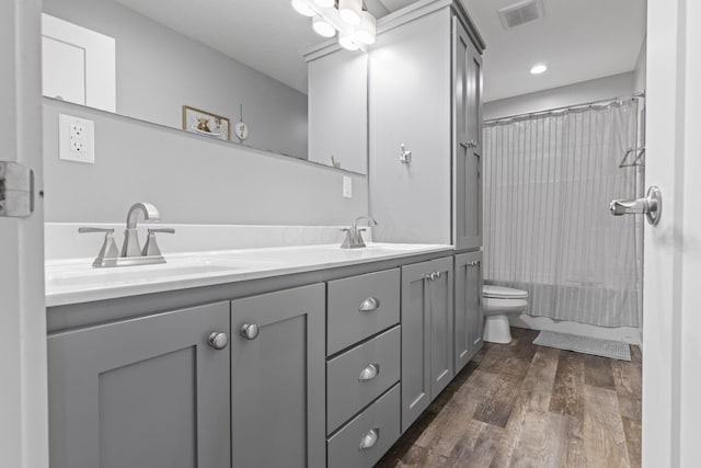 10695 State Route 93 N, Logan, OH 43138 - full bathroom featuring double vanity, visible vents, a sink, and wood finished floors