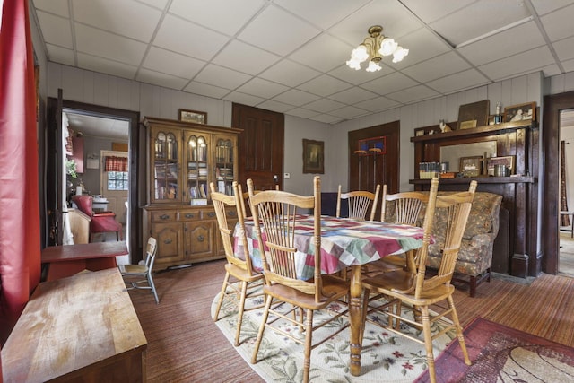 10695 State Route 93 N, Logan, OH 43138 - dining space with carpet flooring, a drop ceiling, a chandelier, and wood walls