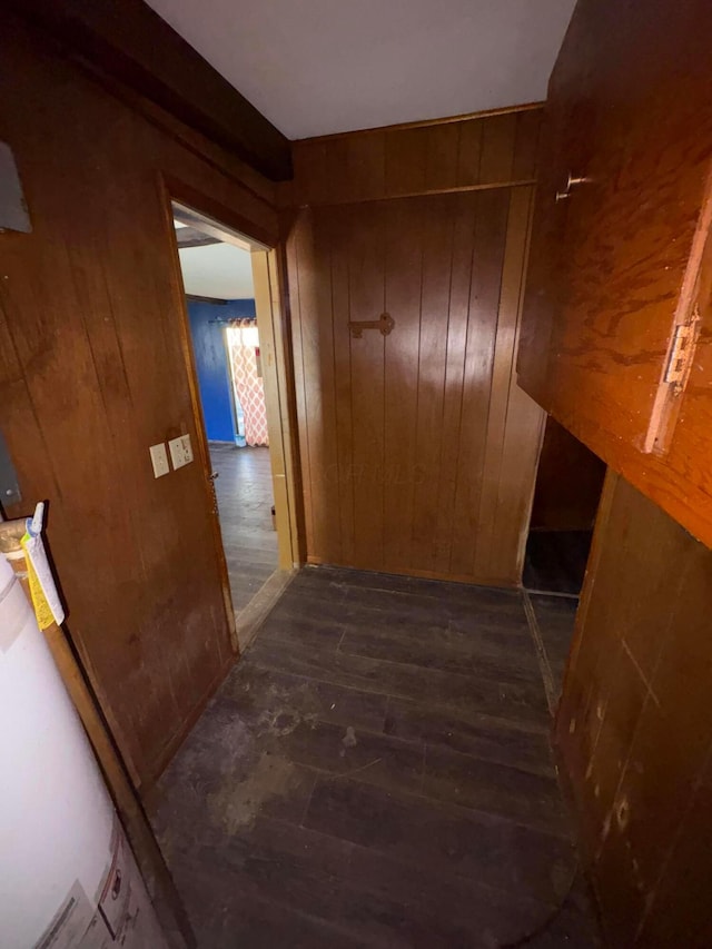 corridor with wooden walls and dark wood finished floors
