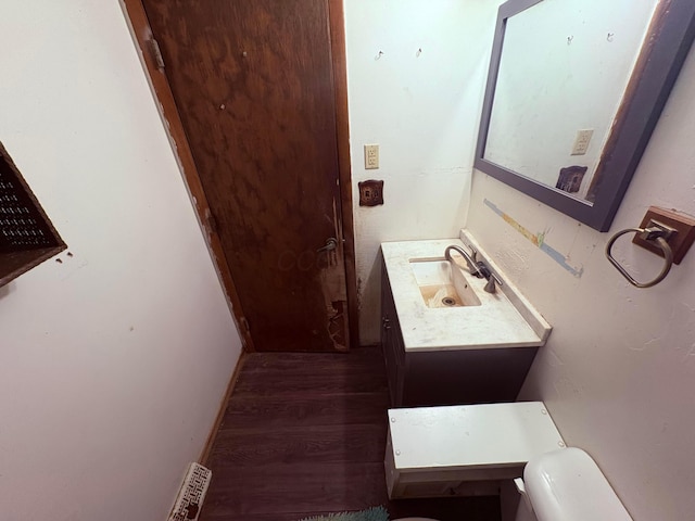 bathroom with vanity, toilet, wood finished floors, and visible vents