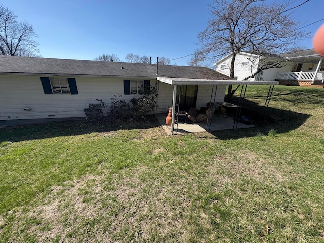 back of house featuring a lawn and a patio area