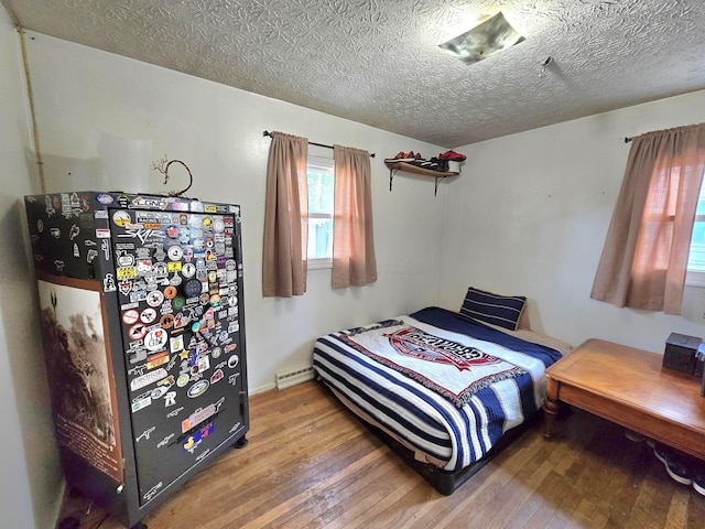 4518 Broadhurst Dr, Columbus, OH 43213 - bedroom featuring a textured ceiling, refrigerator, and hardwood / wood-style floors