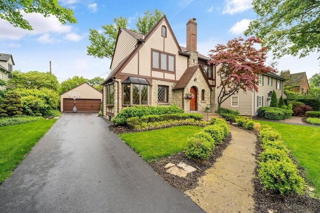 1920 Chatfield Rd, Columbus, OH 43221 - tudor home featuring stone siding, a garage, an outbuilding, stucco siding, and a chimney