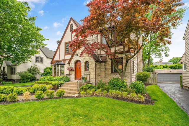 1920 Chatfield Rd, Columbus, OH 43221 - tudor home featuring stone siding, a front yard, stucco siding, and a garage