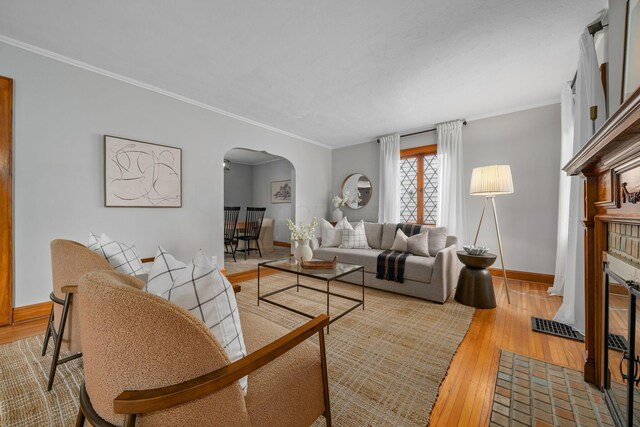 1920 Chatfield Rd, Columbus, OH 43221 - living area featuring arched walkways, hardwood / wood-style floors, a fireplace, crown molding, and baseboards
