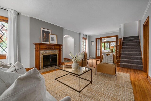 1920 Chatfield Rd, Columbus, OH 43221 - living area featuring arched walkways, light wood-style floors, a fireplace with flush hearth, stairs, and ornamental molding
