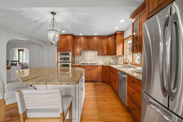 1920 Chatfield Rd, Columbus, OH 43221 - kitchen with appliances with stainless steel finishes, arched walkways, a sink, a breakfast bar area, and light stone counters