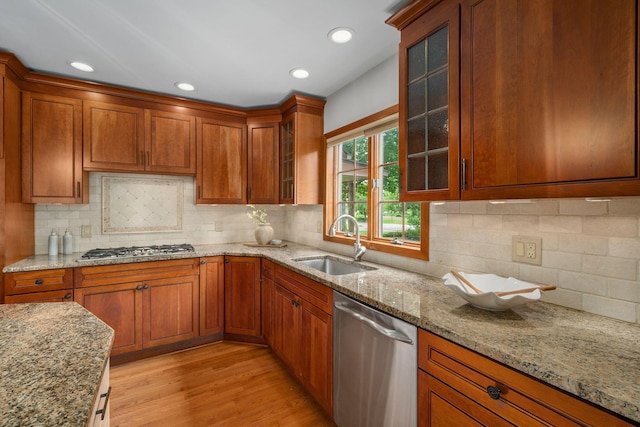 1920 Chatfield Rd, Columbus, OH 43221 - kitchen with appliances with stainless steel finishes, a sink, brown cabinetry, light stone counters, and light wood-style floors