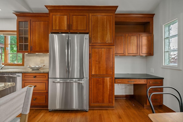 1920 Chatfield Rd, Columbus, OH 43221 - kitchen with freestanding refrigerator, light wood finished floors, brown cabinetry, and glass insert cabinets