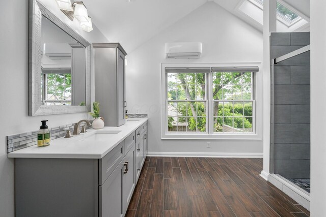 1920 Chatfield Rd, Columbus, OH 43221 - full bath with a skylight, a wall mounted air conditioner, double vanity, vaulted ceiling, and wood finished floors