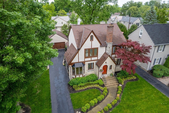 1920 Chatfield Rd, Columbus, OH 43221 - tudor house featuring stone siding, stucco siding, a front yard, and an outbuilding
