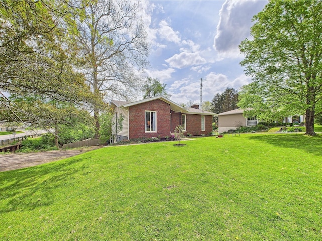 view of front of property featuring brick siding, a chimney, and a front yard