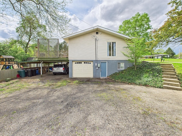 view of side of property with an attached garage, a wooden deck, dirt driveway, stairway, and a carport