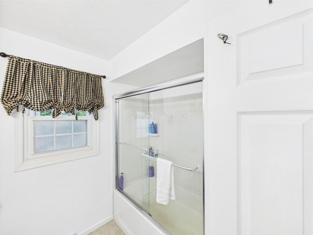 bathroom with bath / shower combo with glass door