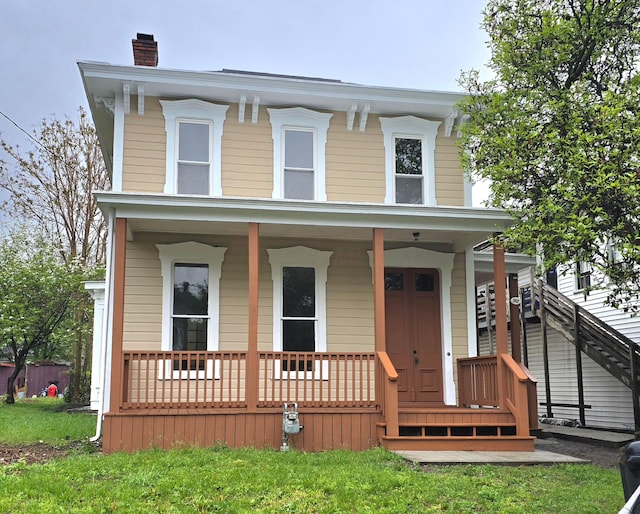 italianate home featuring covered porch and a chimney