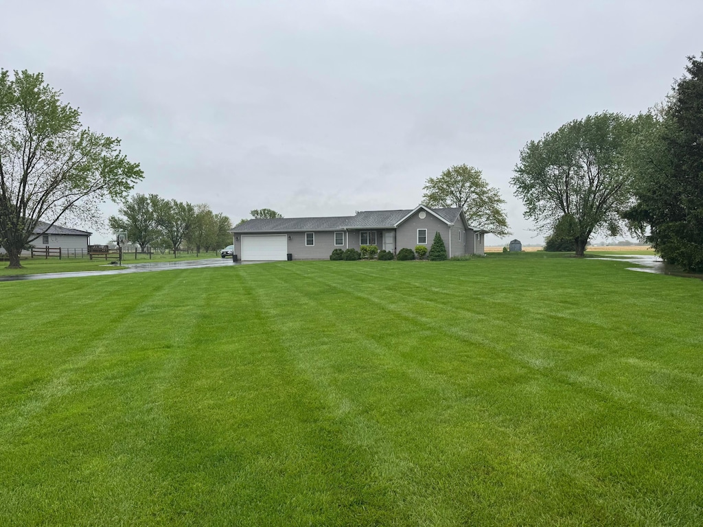 view of yard with an attached garage and driveway