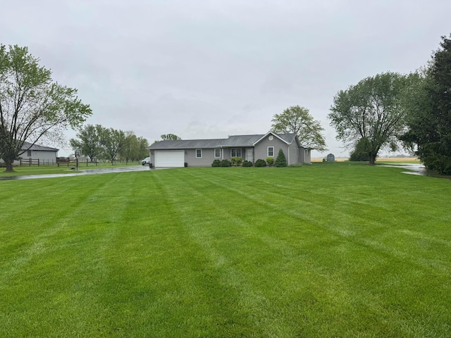view of yard with an attached garage and driveway