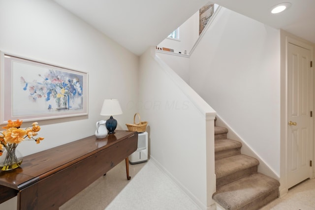 stairs featuring baseboards and carpet flooring
