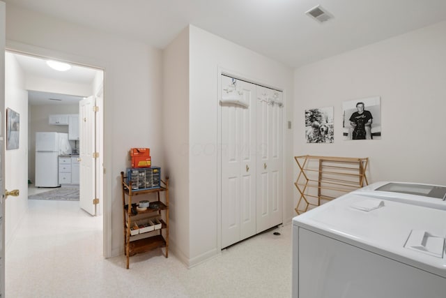 clothes washing area with visible vents, laundry area, baseboards, and washer / clothes dryer