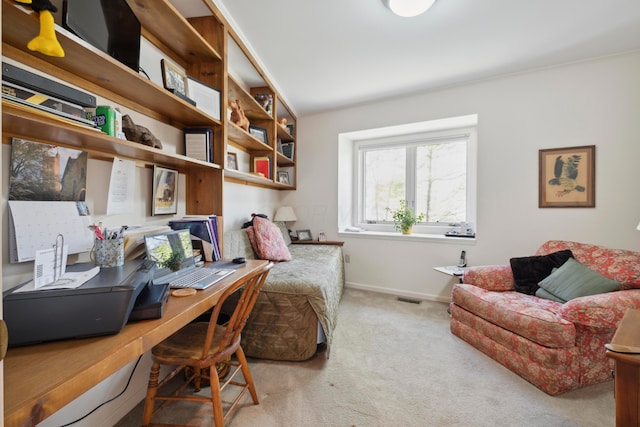 carpeted home office with built in study area, baseboards, and visible vents
