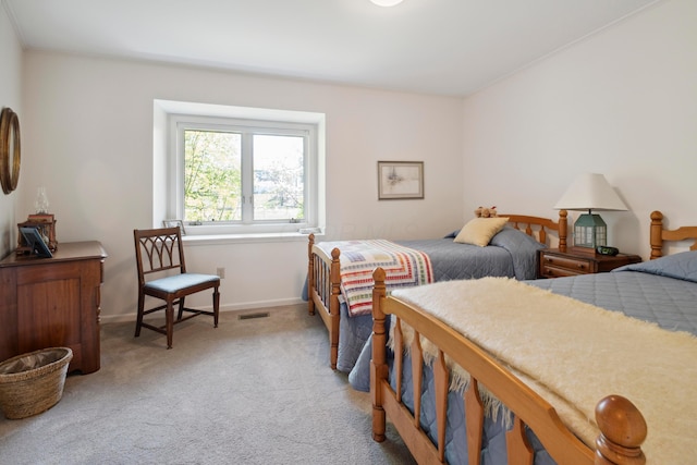 bedroom with baseboards, light carpet, and visible vents