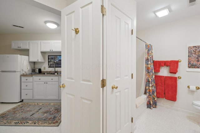 interior space featuring toilet, a shower with curtain, visible vents, and a sink