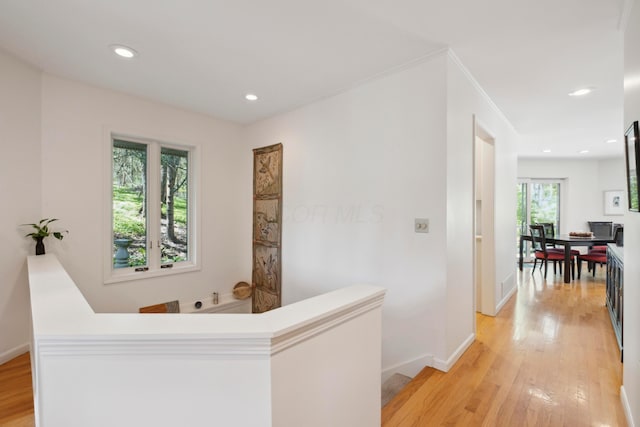 corridor with baseboards, recessed lighting, light wood finished floors, and an upstairs landing
