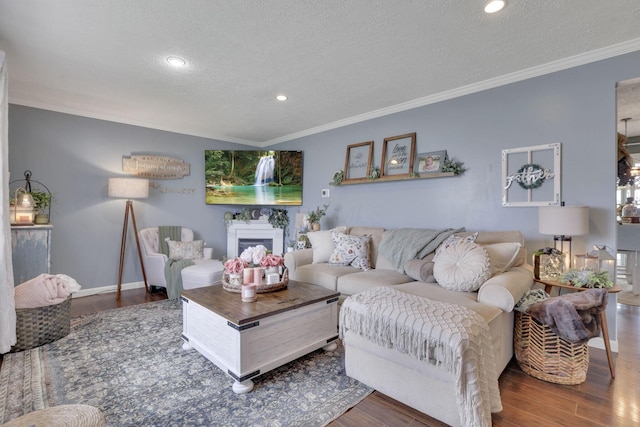 living room with a textured ceiling, ornamental molding, and wood finished floors