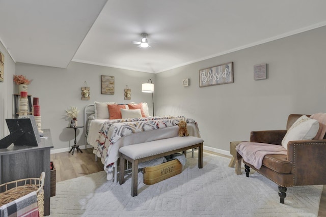 bedroom featuring baseboards, ornamental molding, a ceiling fan, and wood finished floors