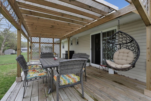 wooden terrace featuring outdoor dining space and a yard