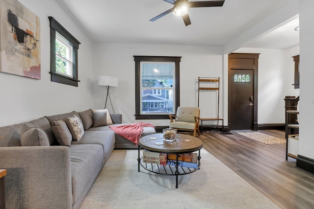 living area with a ceiling fan and wood finished floors