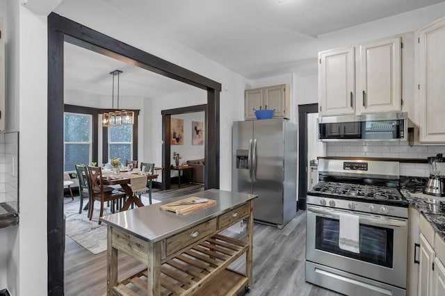 kitchen featuring tasteful backsplash, stainless steel appliances, and light wood finished floors
