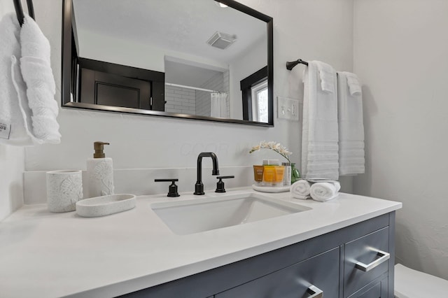 full bathroom featuring vanity, curtained shower, and visible vents