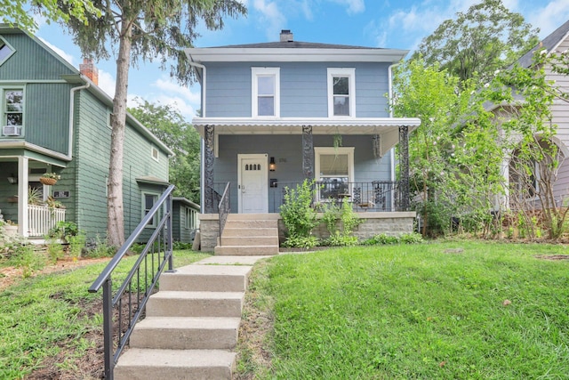 american foursquare style home with a chimney, a porch, stairway, and a front yard