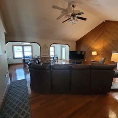 16900 Thompson Ridge Rd, Laurelville, OH 43135 - living area with high vaulted ceiling, dark wood-type flooring, ceiling fan, arched walkways, and wooden walls